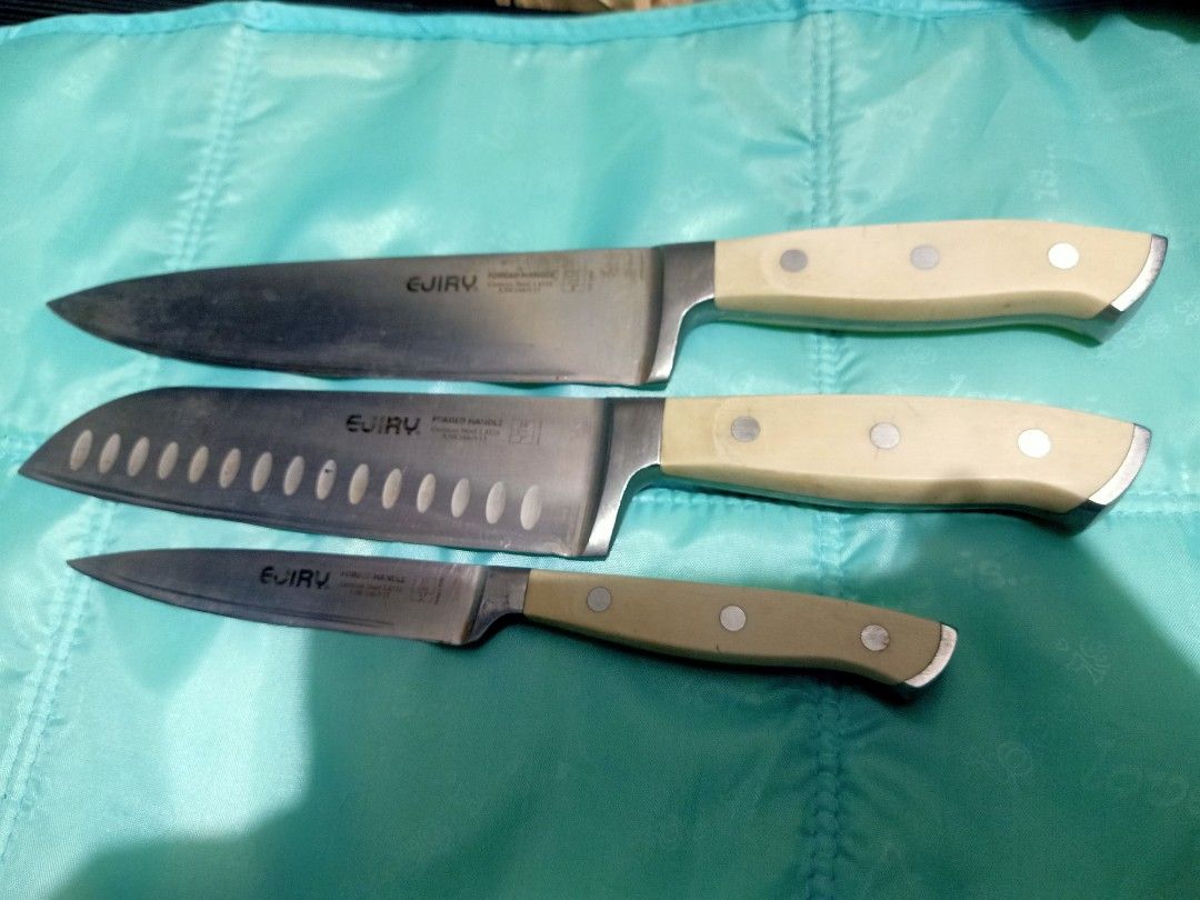 EJIRY Forged Handle Kitchen Knives Set - German Steel (Category: Knives & Chopping Boards) located in Pasig City. Submitted by urdal01 (Listing ID 1454129669, Image 2). Description: - Set of 3 EJIRY kitchen knives - Includes: Chef's knife, Santoku knife (with air holes), Paring knife - Material: German steel blades, forged handles - Condition: Blades are sharp with some signs of use - Handle color: Light cream - Ideal for: Everyday cooking.