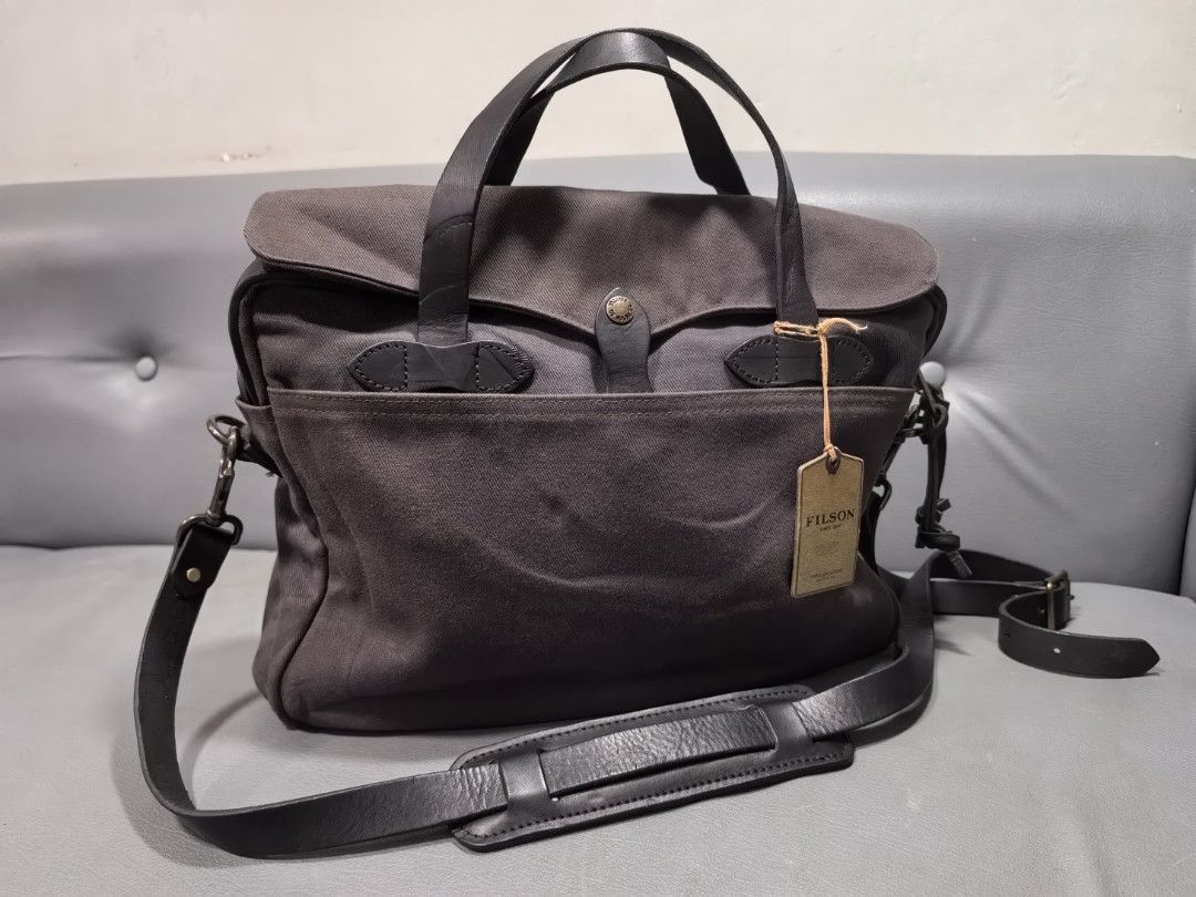 Filson 2-Way Bag Cinder (Category: Briefcases) located in Cagayan de Oro. Submitted by pootx (Listing ID 1454145526, Image 1). Description: - Filson Briefcase in Cinder color - Made in USA - Crafted from 100% Cotton and Cow Leather - Features durable Brass Hardware - Main zippered compartment with internal pockets - Additional external pocket for quick access - Versatile carrying options: top handles or adjustable shoulder strap - Ideal for both 