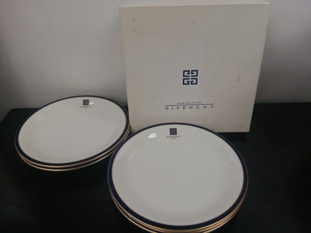 Givenchy dinner plates (Category: Dinnerware & Cutlery) located in San Pedro. Submitted by thriftersp47808 (Listing ID 1454137283, Image 1). Description: This is an authentic Givenchy Paris porcelain dinnerware plate, manufactured in Japan under official license by Yamaka International. [1, 2] Design Details Pattern: Classic white porcelain center accented with a distinct dark cobalt blue and thin gold trim along the rim. Logo Branding: Features 