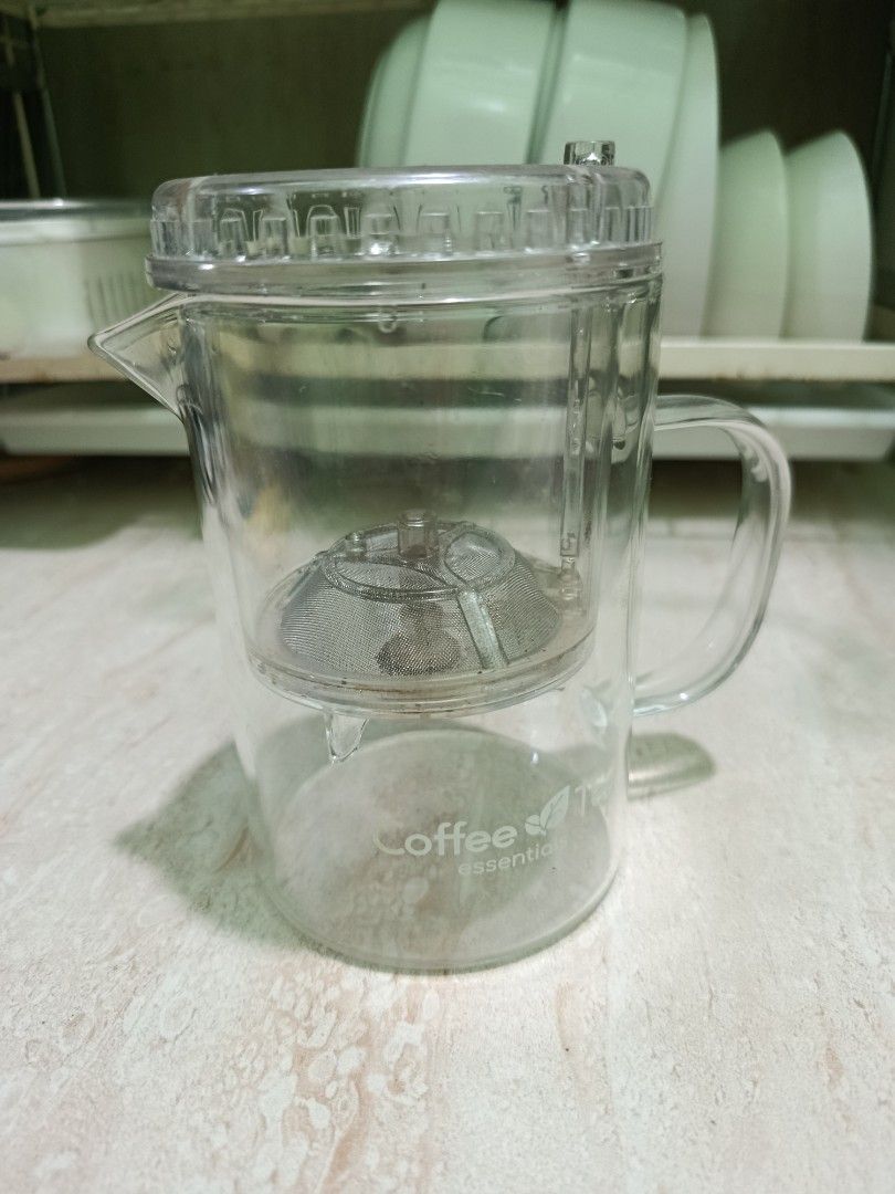 Glass Tea Infuser Pot with Strainer (Category: Coffee & Tea Tableware) located in Taguig. Submitted by prelovedbydarra (Listing ID 1454036880, Image 1). Description: - Clear glass teapot with built-in mesh strainer - Ideal for brewing loose leaf tea or coffee - Features a comfortable handle and easy-pour spout - 'Coffee essentials' logo detail - Simple to use and clean - Perfect for single servings.
