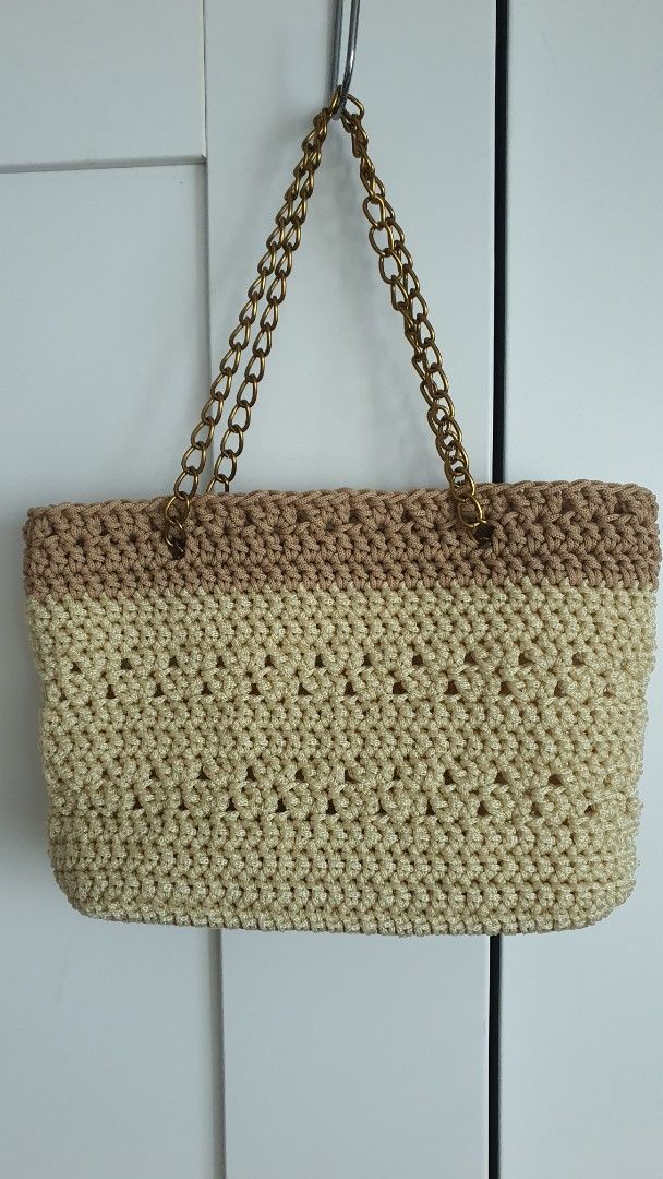 Handmade Crocheted Bag with Chain Strap (Category: Purses & Pouches) located in Quezon City. Submitted by celestial_matters (Listing ID 1454098751, Image 1). Description: - Cute handmade crochet purse or clutch - Beige and brown color combination - Features a stylish gold chain strap - Intricate and unique crochet pattern - Spacious interior for your essentials - Ideal for cocktail events or as a statement accessory - bottom : 6.5" long & 1.75" w