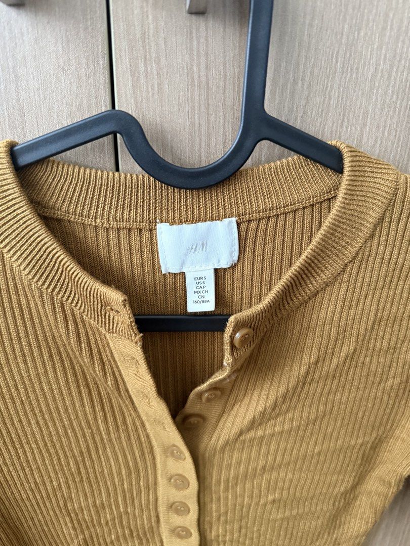 H&M Mustard Yellow Ribbed Button Up Long Sleeve Top (Category: Longsleeves) located in Tuguegarao City. Submitted by Jarah (Listing ID 1454079261, Image 2). Description: - Mustard yellow long sleeve top - Brand: H&M - Material: Ribbed knit - Features: Button-up neckline - Versatile: Great for layering or wearing alone - Style: Comfortable and stylish for everyday wear - fits xs to small frames.