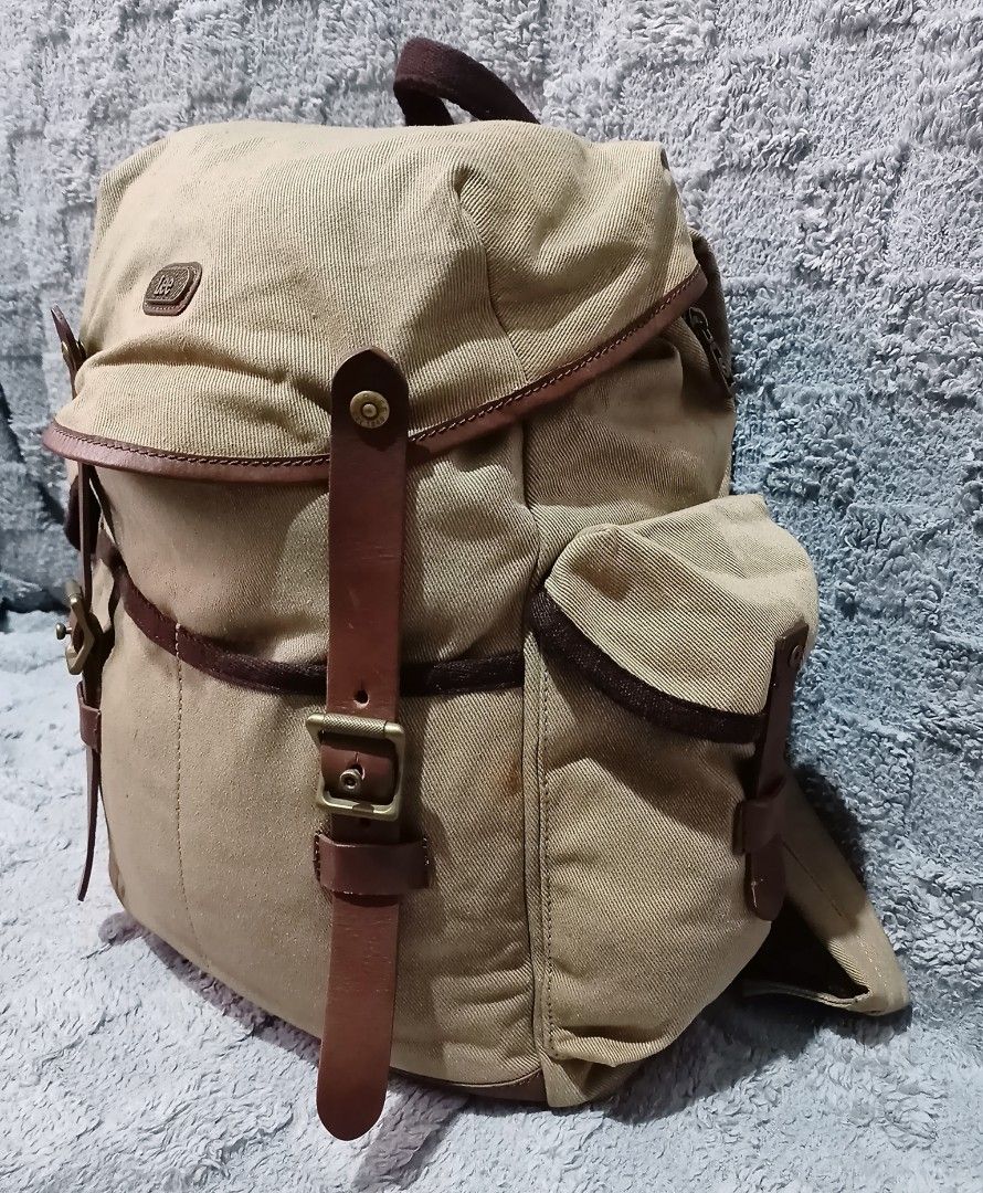 Lee canvas rucksack backpack (Category: Backpacks) located in Asingan. Submitted by arnelpalaris8 (Listing ID 1454184741, Image 3). Description: Lee canvas rucksack Backpack Color:khaki Verygood condition Need wash 📌Brand Detail: A stitched faux-leather patch on the upper flap displays the classic cursive Lee logo script. 📌Storage Setup: It includes a spacious drawstring main compartment covered by a buckled top flap, complemented by two symmet