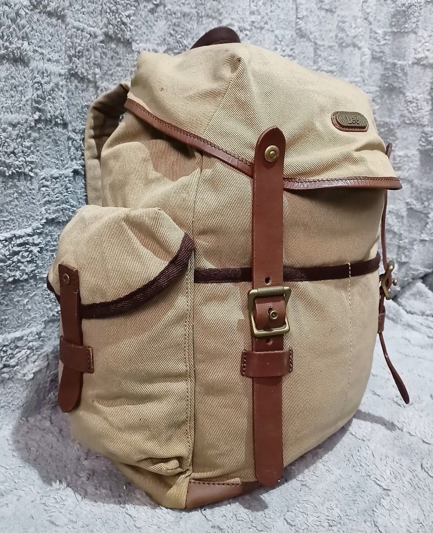Lee canvas rucksack backpack (Category: Backpacks) located in Asingan. Submitted by arnelpalaris8 (Listing ID 1454184741, Image 2). Description: Lee canvas rucksack Backpack Color:khaki Verygood condition Need wash 📌Brand Detail: A stitched faux-leather patch on the upper flap displays the classic cursive Lee logo script. 📌Storage Setup: It includes a spacious drawstring main compartment covered by a buckled top flap, complemented by two symmet