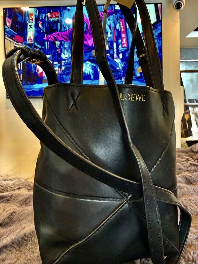 Leowe Puzzle Fold (Category: Cross-body Bags) located in Manila. Submitted by source.selection (Listing ID 1454097751, Image 2). Description: This black Loewe Puzzle Fold Tote Mini is crafted from grained calfskin and features signature geometric paneling with a gold-embossed logo..