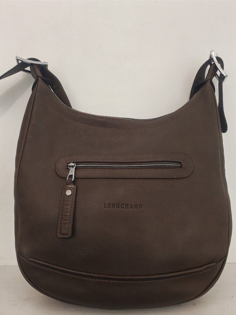 Longchamp Cosmos Sac leather bag (Category: Luxury Bags & Wallets) located in Quezon City. Submitted by destashingme (Listing ID 1454087296, Image 1). Description: measures : 16 inches wide x 12 at its lowest zipper point. strap is adjustable. It is in excellent condition. no rips or marks. - Authentic Brown Leather Longchamp Hobo Bag - Textured leather finish for a sophisticated look - Convenient front zipper pocket for essentials - Adjustable s