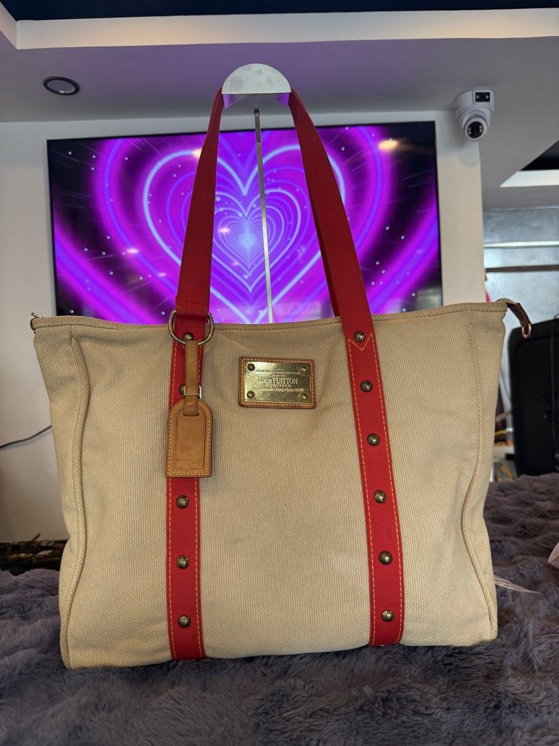 Louis Vuitton Antigua Cabas GM (Category: Tote Bags) located in Manila. Submitted by source.selection (Listing ID 1454084417, Image 1). Description: This Louis Vuitton Antigua Cabas GM tote bag features beige canvas with red strap details and a gold-tone brass plaque..