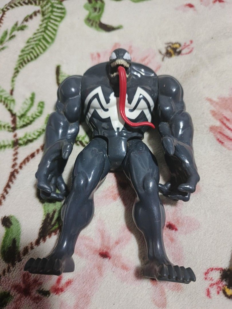 Marvel Venom Action Figure with Tongue (Category: Figurines & Statues) located in Caloocan City. Submitted by deleonmaik02060 (Listing ID 1454137464, Image 1). Description: - Iconic Venom action figure - Dark gray with striking white spider symbol - Features a signature red tongue sticking out - Poseable limbs for dynamic display - Stands independently - A must-have for any Marvel fan's collection.