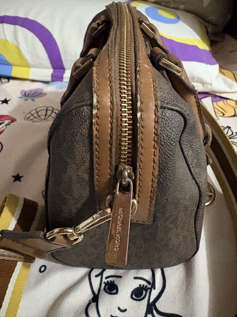Michael Kors Monogrammed Barrel Bag with Strap (Category: Luxury Bags & Wallets) located in Munoz. Submitted by Liiz27 (Listing ID 1454065553, Image 3). Description: - Authentic Michael Kors barrel bag - Signature MK monogram print - Comes with a brown and yellow striped crossbody strap - Gold hardware details - Interior zip pocket - Minor signs of wear on leather trim and interior.