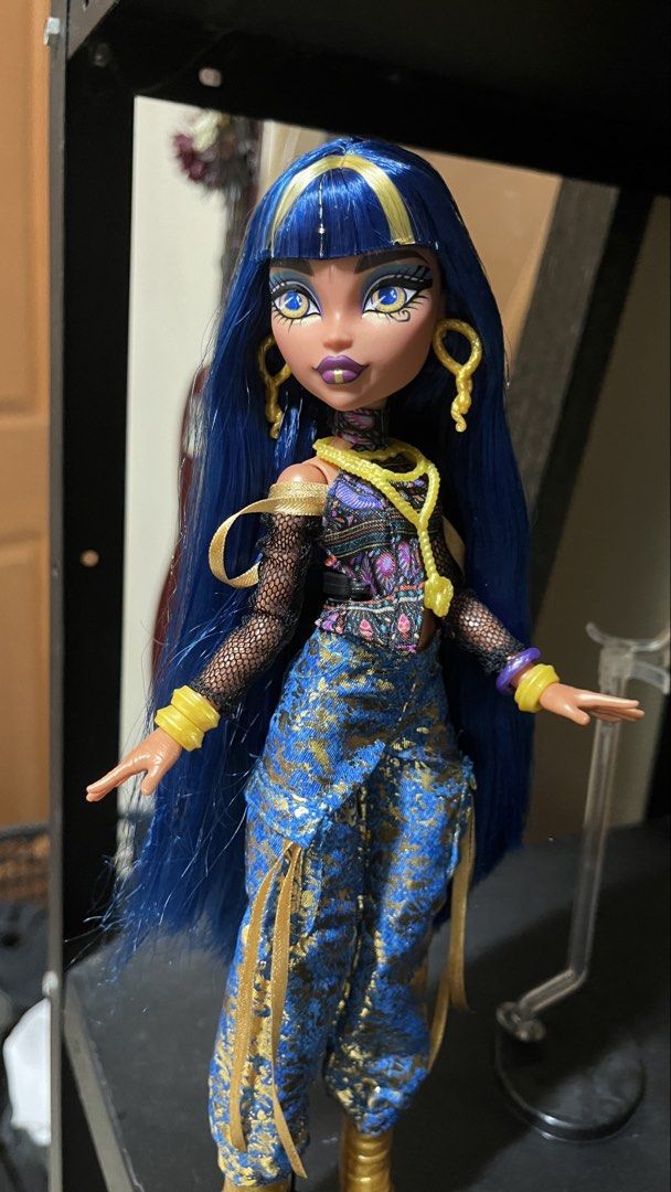 Monster High Doll Cleo De Nile G2 (Category: Figurines & Statues) located in Quezon City. Submitted by declutteringsquirrel (Listing ID 1454066070, Image 2). Description: - Monster High Cleo De Nile doll - Long blue hair with gold streaks - Outfit: Black mesh top, colorful patterned vest, blue patterned pants - Includes gold accessories: earrings, bracelets, necklace .