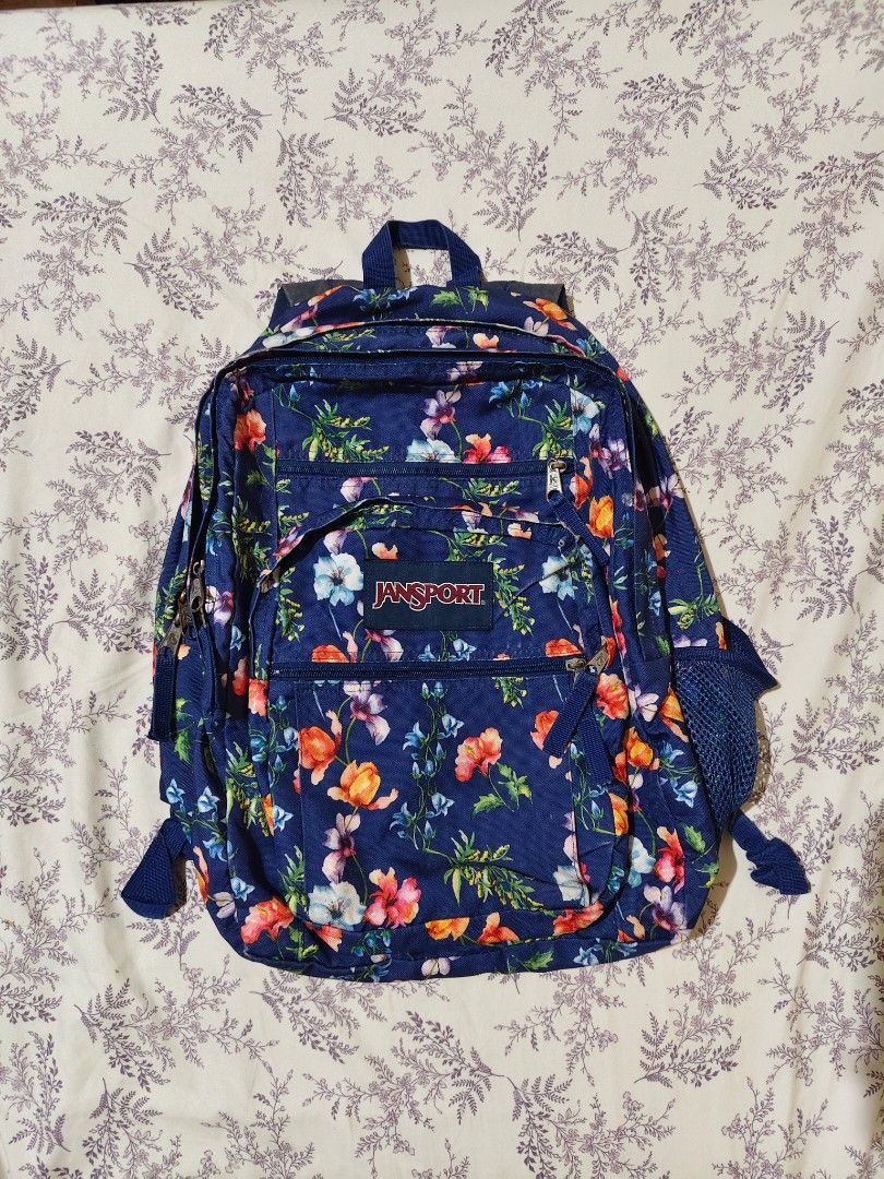 navy floral JanSport Big Student backpack (Category: Luxury Bags & Wallets) located in Bulacan. Submitted by angel.decluttersx (Listing ID 1454166181, Image 2). Description: first purchased ₱4,500 at SM dept store many compartments pre-loved flaw: sign of usage: faded color sa back upper and loose garterized yung left one side ng bag.