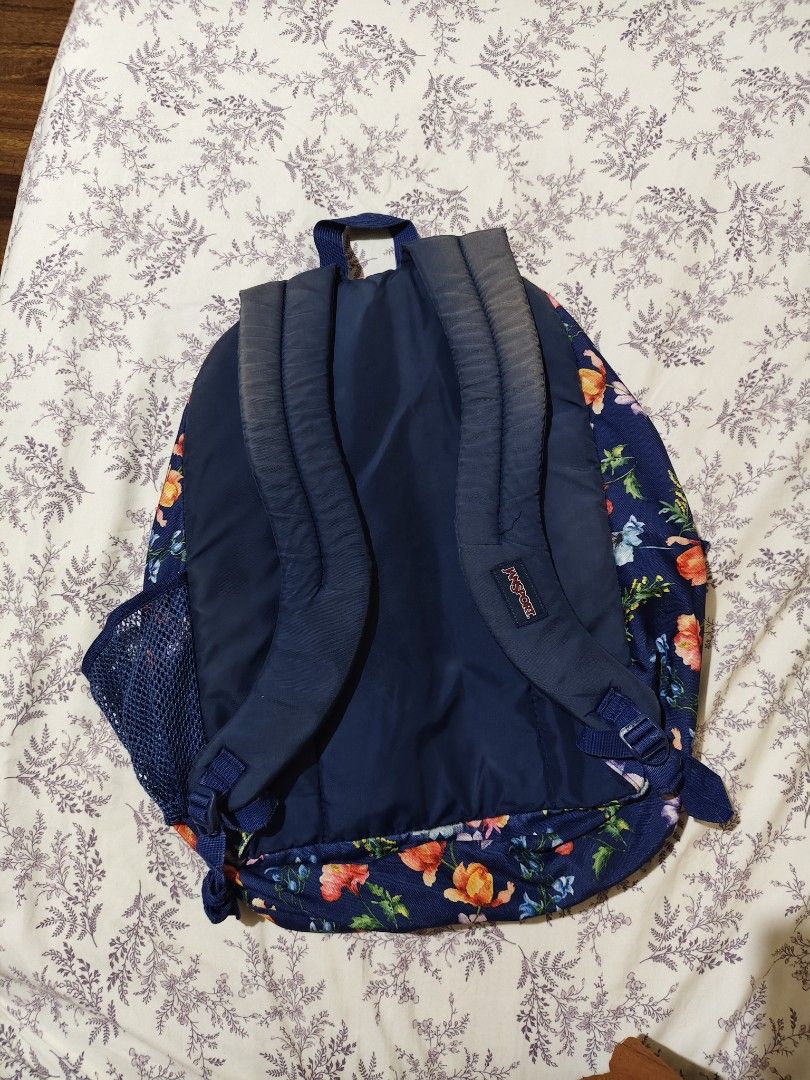 navy floral JanSport Big Student backpack (Category: Luxury Bags & Wallets) located in Bulacan. Submitted by angel.decluttersx (Listing ID 1454166181, Image 3). Description: first purchased ₱4,500 at SM dept store many compartments pre-loved flaw: sign of usage: faded color sa back upper and loose garterized yung left one side ng bag.