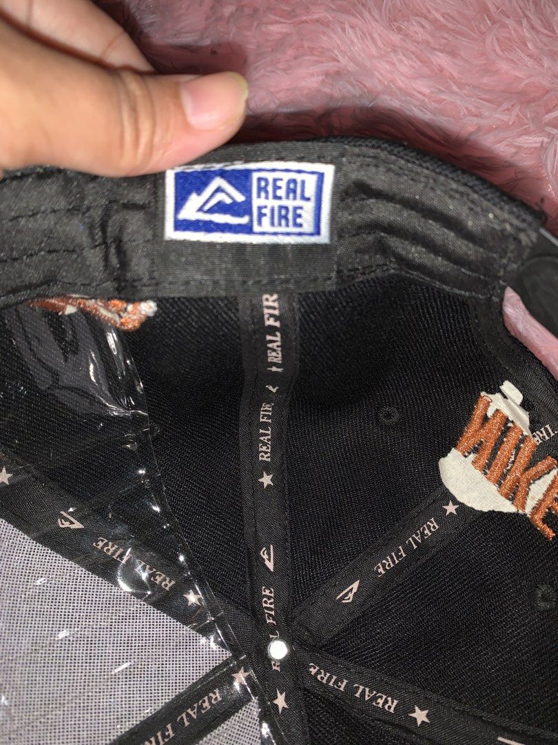 Nike Snapback Cap - Black with Orange Swoosh (Category: Caps & Hats) located in Binan City. Submitted by kariray_shop (Listing ID 1454065965, Image 3). Description: - Classic black Nike snapback cap - Iconic orange Nike swoosh logo - 'NIKE' embroidered in orange on the side - Unique 'REAL FIRE' branding inside - Adjustable snap closure for a custom fit.