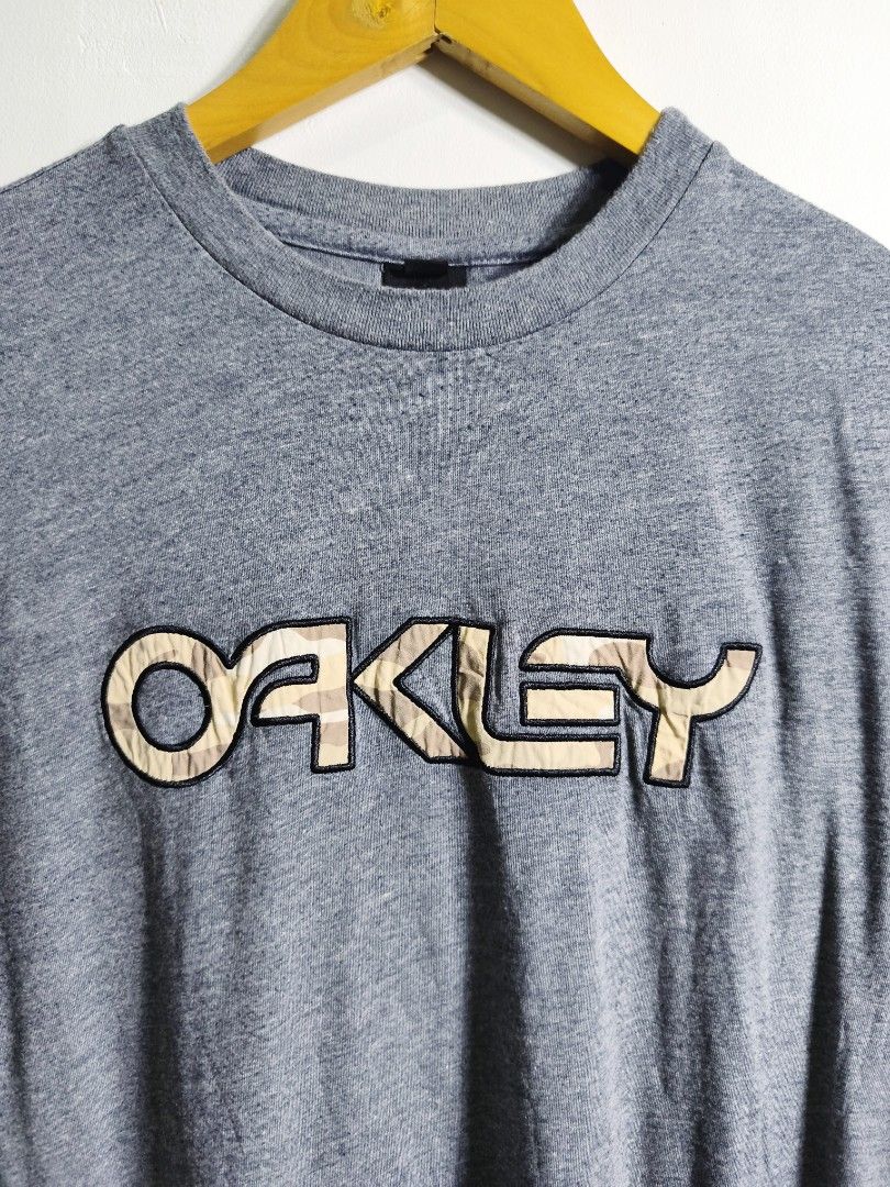 Oakley Tee (Category: Tshirts & Polo Shirts ) located in Paranaque City. Submitted by pickersform (Listing ID 1454113346, Image 2). Description: Oakley Tee size small fits Medium width: 20 / length: 28 - Features Oakley embroidered logo with camouflage fill cut washtag only still 100% authentic .