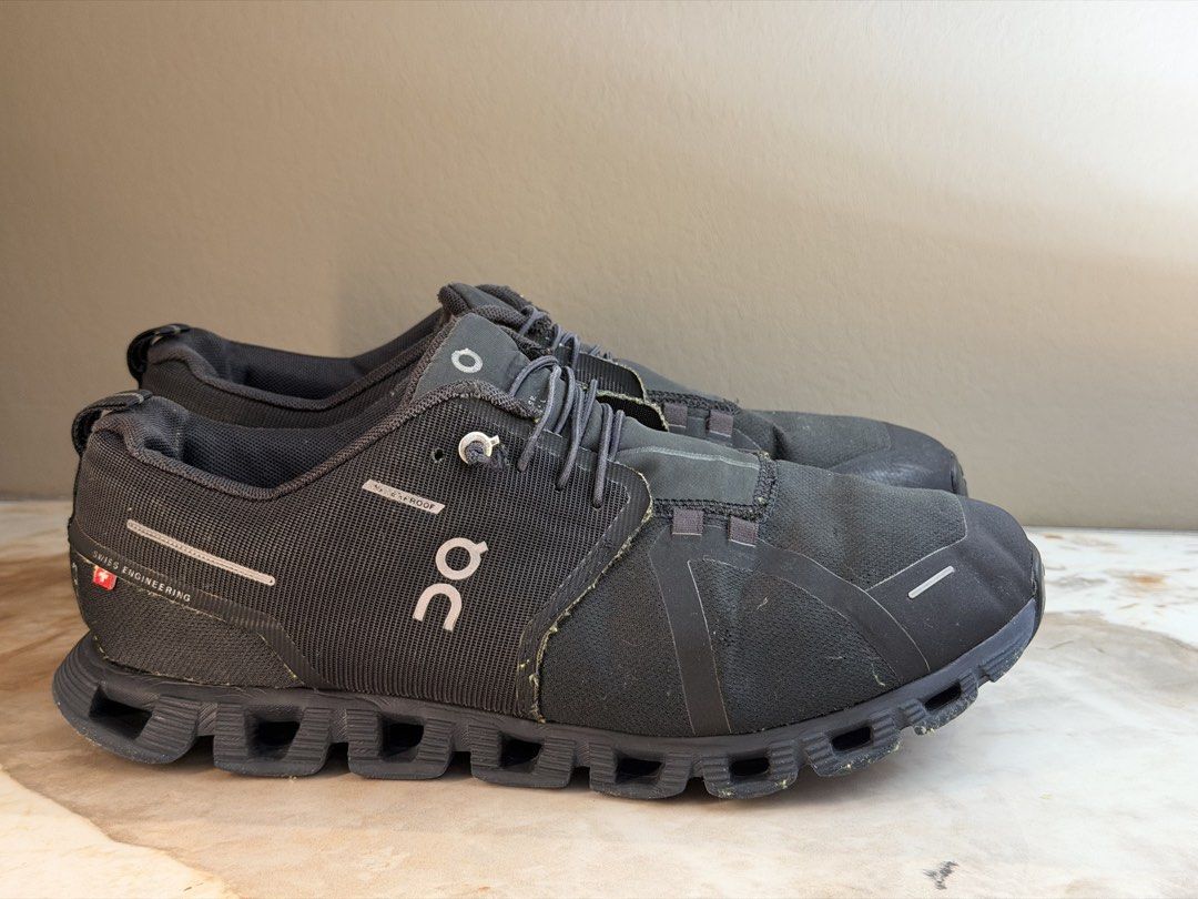 On Cloud 5 Waterproof Running Shoes (Category: Sneakers) located in Manila. Submitted by penkua (Listing ID 1454156358, Image 3). Description: - On Cloud running shoes - Swiss Engineering - Versatile: Great for running or everyday wear - Color: Black with grey laces - Signature On Cloud sole design - Minor dust from storage, ready for a new owner.