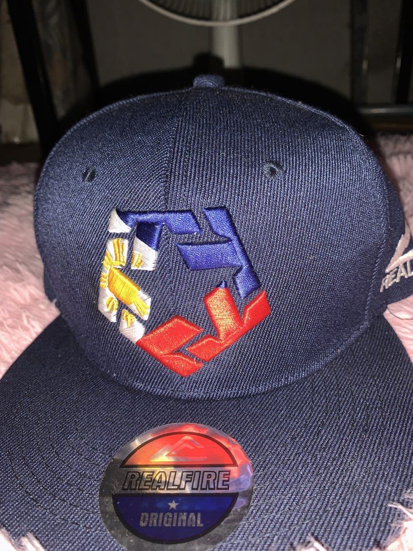 Real Fire Original Snapback Cap (Category: Caps & Hats) located in Binan City. Submitted by kariray_shop (Listing ID 1454066745, Image 1). Description: - Brand: Real Fire - Color: Navy Blue - Style: Snapback Cap - Features: Original design with embroidered logo on front and side - Fit: Adjustable strap at the back - Occasion: Casual wear.