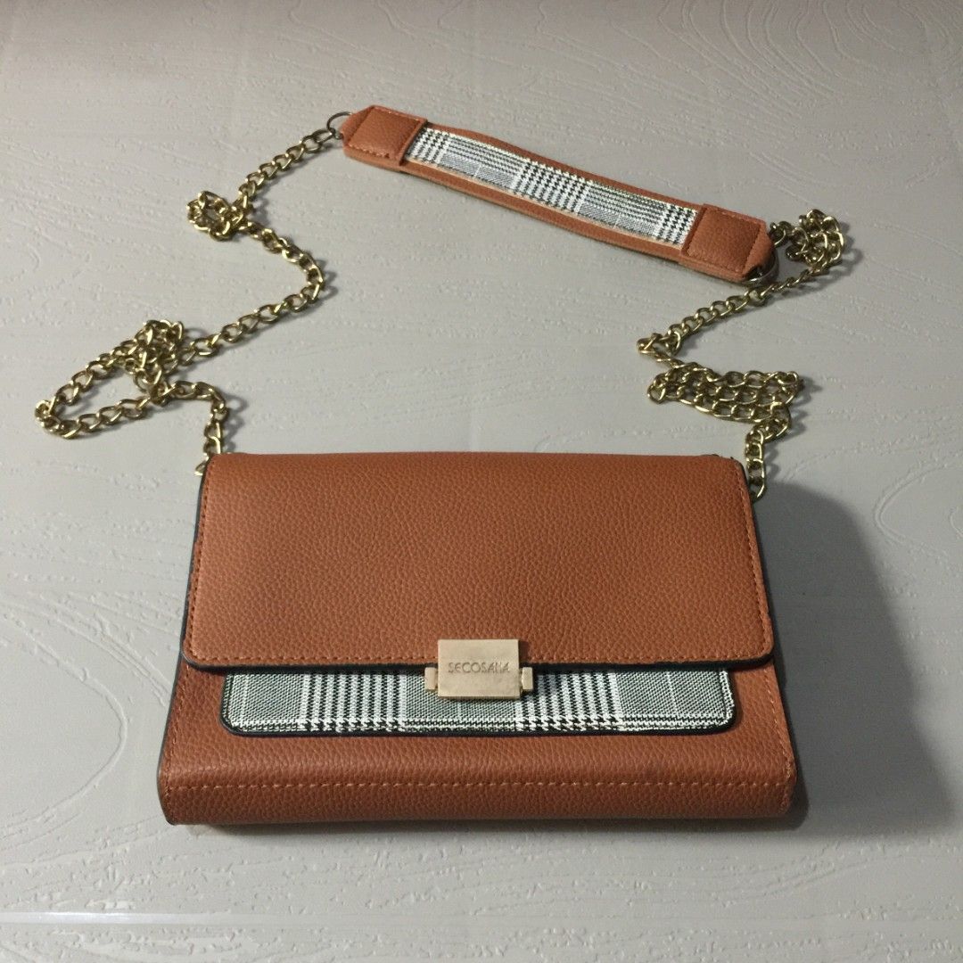 Secosana Brown Tan Sling Bag Chain Shoulder Strap (Category: Cross-body Bags) located in Pasig City. Submitted by butfirst.declutter (Listing ID 1454031085, Image 3). Description: - Lightly used - Only issue, replaced one chain, vsee photo - No dents - Color may vary due to lighting - See photos for measurements - Manage your expectations since this is a preloved item. You can message me for inquiries. Kindly read my ‘About’ :> Price is negotiabl