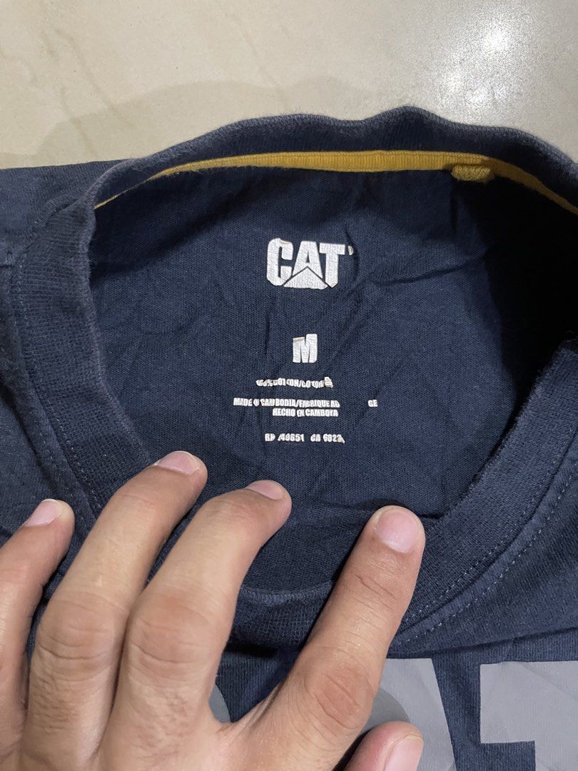 CAT T-Shirt Size M Navy Blue (Category: Tshirts & Polo Shirts ) located in Manila. Submitted by stuzzygod (Listing ID 1454343651, Image 2). Description: - Navy blue CAT t-shirt - Features classic CAT logo on front - Made from 100% cotton - Tagged size M - Ideal for casual wear - Dimes 21.5x28 - No issue - Good condition.