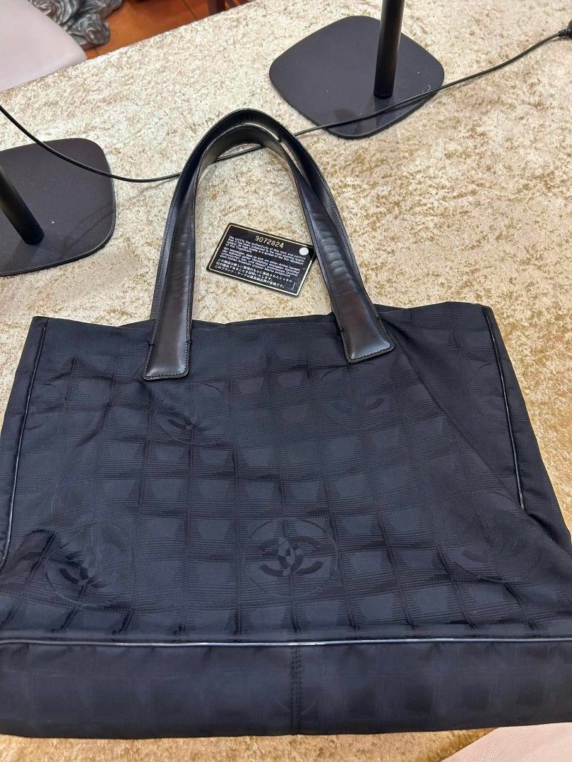 Chanel Black Nylon CC Logo Tote Bag (Category: Luxury Bags & Wallets) located in Manila. Submitted by mippolin (Listing ID 1454237867, Image 3). Description: - Authentic Chanel tote bag - Color: Black nylon with repeating CC logo pattern - Material: Leather handles and trim - Interior: Spacious with zippered pockets - Ideal for: Everyday use or travel - Authenticity: Comes with authenticity card money back guaranteed from Japan.