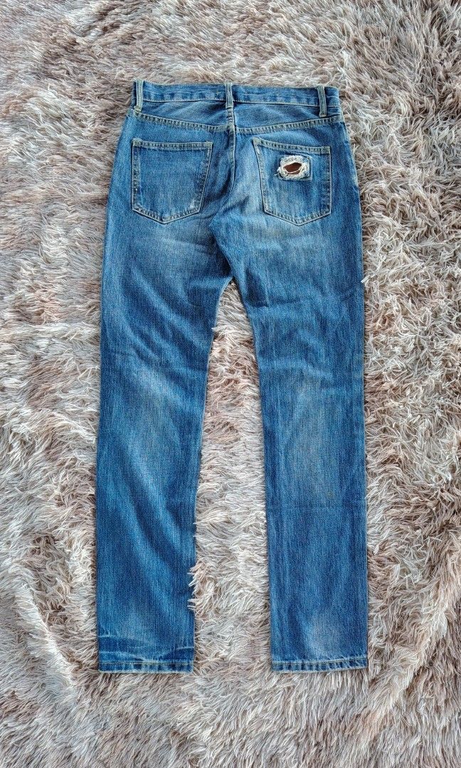 DOLCE & GABBANA DISTRESSED JEANS👖 (Category: Jeans) located in Bislig. Submitted by tuazons21 (Listing ID 1454199872, Image 3). Description: DOLCE & GABBANA DISTRESSED JEANS👖 SIZE : 31 ON TAG ACTUAL WAIST LINE : 31 LENGTH : 41 HEM : 6.5 CR : 9.8/10 EXCELLENT CONDITION DETAILS POSTED⤵️ MURA LANG💸 DM TO PURCHASE 📩📩 A stylish man wearing these Dolce & Gabbana slim-fit blue denim jeans — featuring faded medium-blue wash, heavily distressed rippe