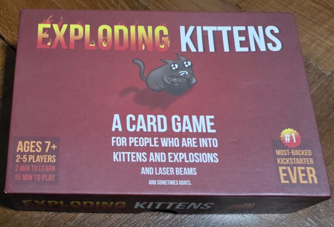 Exploding Kittens Card Game (Category: Board Games & Puzzles) located in Singapore. Submitted by silversnows (Listing ID 1454312862, Image 1). Description: - Exploding Kittens Card Game - Perfect for 2-5 players - Suitable for ages 7 and up - Learn in just 2 minutes - Games take approximately 15 minutes - Features kittens, explosions, laser beams, and goats - Was the most-backed Kickstarter project ever!.