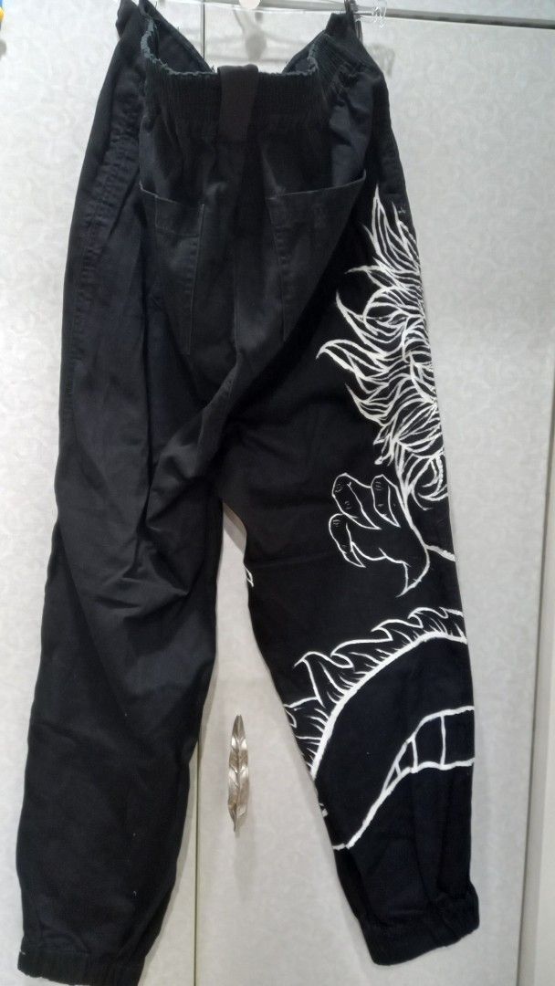 Forever 21 Black Dragon Print Jogger Pants (Category: Joggers) located in Manila. Submitted by miss66449 (Listing ID 1454199452, Image 3). Description: - unisex Forever 21 black jogger pants - Features a cool white dragon graphic print on one leg - Elastic waistband with drawstring - Cuffed ankles - Metal D-rings at the waist - Ideal for casual wear.