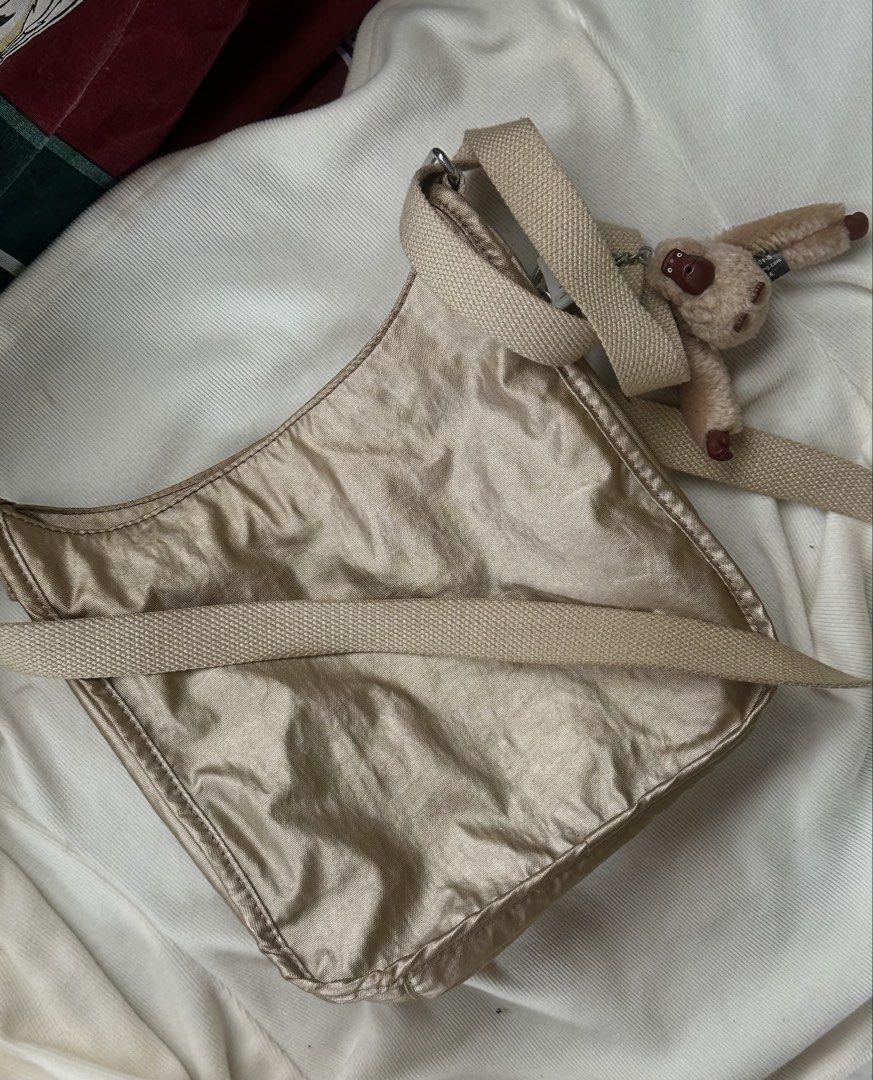 Kipling Metallic Gold Crossbody Bag with Monkey Charm (Category: Cross-body Bags) located in Manila. Submitted by bagified (Listing ID 1454209556, Image 3). Description: - Lightweight Kipling crossbody bag - Beautiful metallic gold color - Iconic Kipling monkey charm included - Features a front pocket - Interior zip pocket for secure storage - Adjustable strap for customized comfort - Ideal for everyday use.