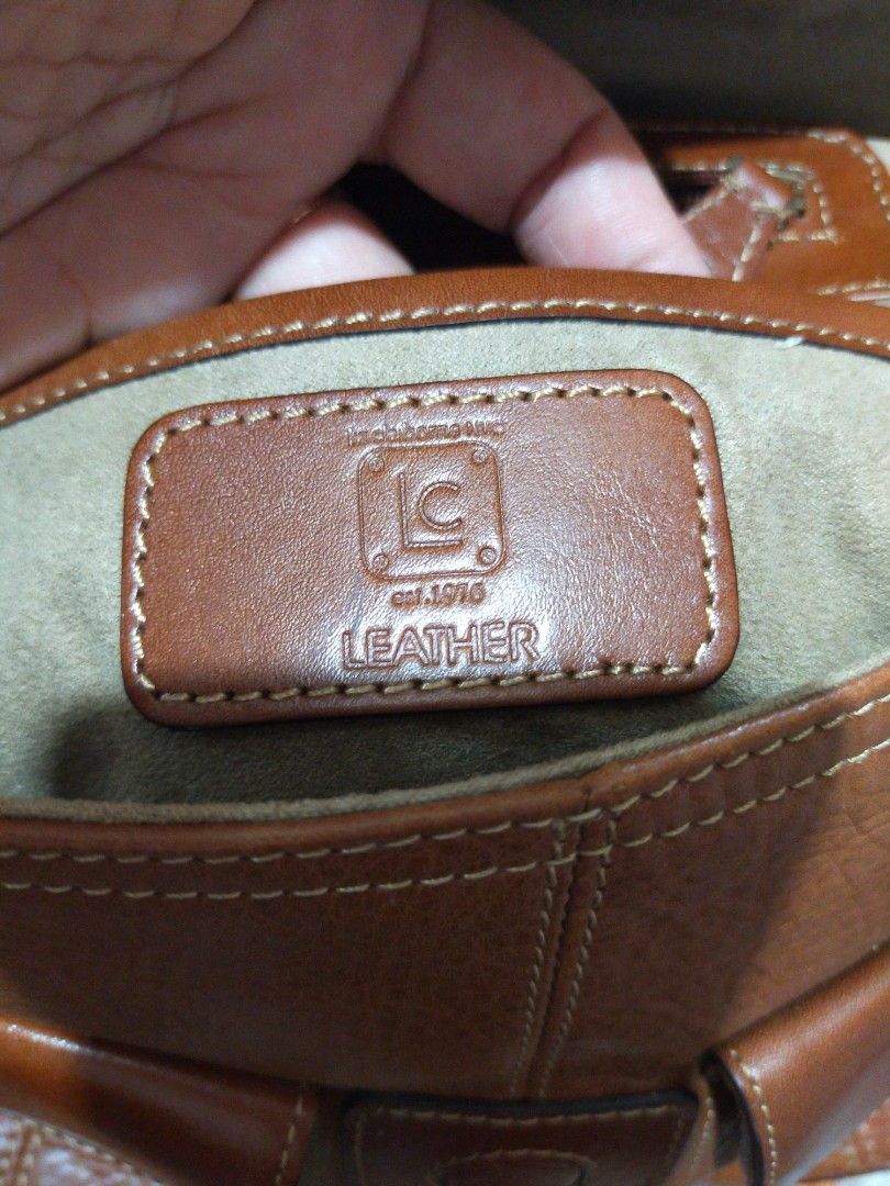 Liz Genuine Leather bag 💯% original (Category: Shoulder Bags) located in Manila. Submitted by new-opening (Listing ID 1454241780, Image 1). Description: Brown leather shoulder bag from LC. Has the LC logo and 'est. 1976 LEATHER' stamped inside. The leather has a nice texture. The strap is adjustable with buckles. Some signs of wear on the strap and edges, but still a solid bag. Plenty of space inside..