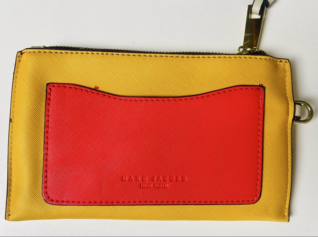 MJ Snapshot Wristlet (Slightly Negotiable) (Category: Purses & Pouches) located in Imus. Submitted by cheratedfinds (Listing ID 1454361095, Image 3). Description: Vibrant yellow and coral pink Saffiano-style flat wristlet with gold-tone hardware! Perfect for quick errands, coffee runs, or organizing your essentials inside a bigger bag. 📌 ITEM DETAILS: • Color: Mustard Yellow / Coral Pink / Cream Strap • Material: Saffiano-style leather finish • 