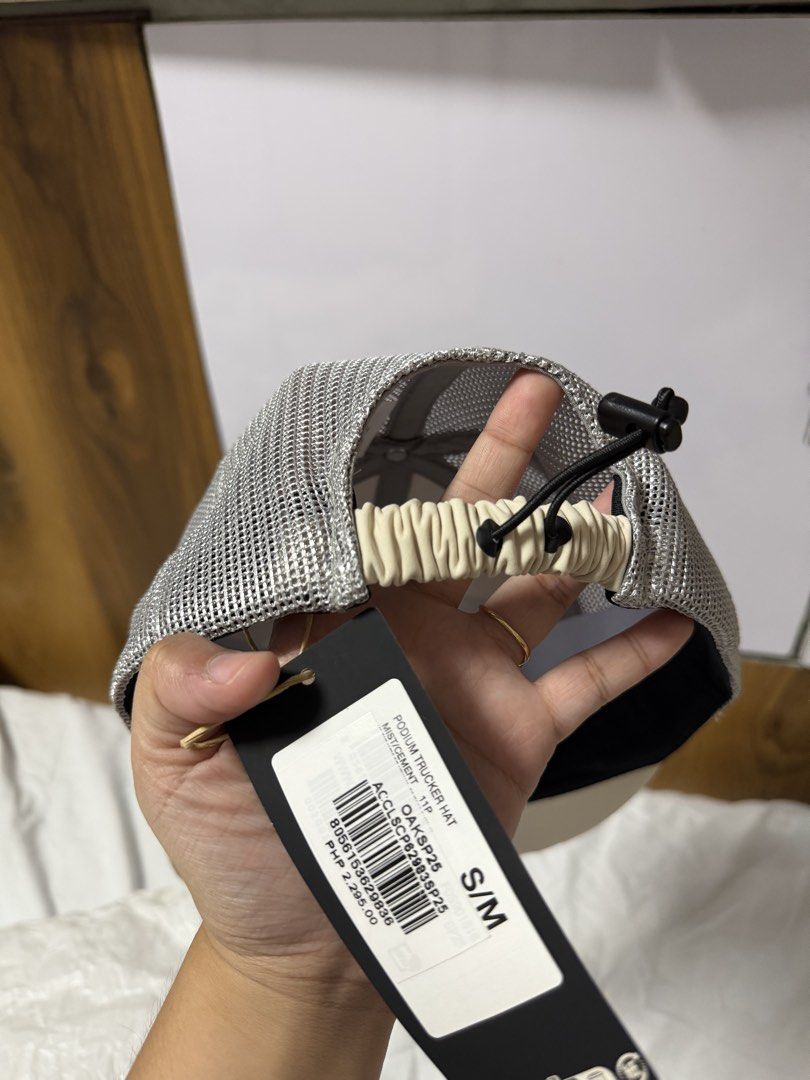 Oakley Podium Trucker Hat S/M Beige Mesh (Category: Caps & Hats) located in Cainta. Submitted by tinpalma (Listing ID 1454209033, Image 2). Description: - Oakley Podium Trucker Hat - Size: S/M - Color: Beige and grey mesh - Features: Adjustable strap at the back with a drawstring - Condition: Comes with original tag - Original Price: PHP 2,295.00.
