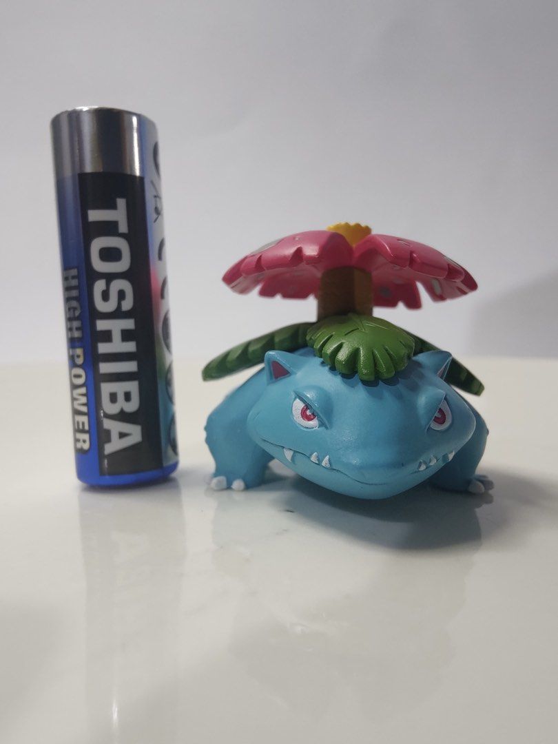 Pokemon Venusaur Figure with Battery for Scale (Category: Figurines & Statues) located in Manila. Submitted by januelle23 (Listing ID 1454205599, Image 1). Description: - Adorable blue Venusaur Pokemon figure PERSONAL PRELOVED EXCELLENT QUALITY SUPER CUTIES 🥰 Mine first to pay - Features a pink flower on its back - Striking red eyes and sharp teeth detail - Ideal for Pokemon fans and collectors - Perfect for displaying on shelves or desks.