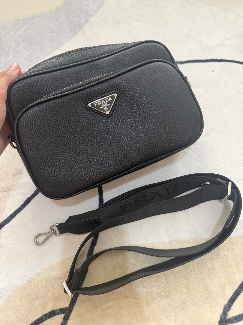 Prada Black Saffiano Leather Camera Bag with Pouch (Category: Luxury Bags & Wallets) located in Cebu City. Submitted by gdcebu (Listing ID 1454198185, Image 1). Description: - Prada Camera Bag - Color: Black - Material: Saffiano Leather - Features: Adjustable Prada shoulder strap, small matching pouch - Interior: Lined with Prada branded fabric - Condition: Smooth zippers, great for everyday use or travel.