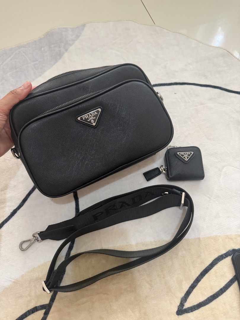 Prada Black Saffiano Leather Camera Bag with Pouch (Category: Luxury Bags & Wallets) located in Cebu City. Submitted by gdcebu (Listing ID 1454198185, Image 2). Description: - Prada Camera Bag - Color: Black - Material: Saffiano Leather - Features: Adjustable Prada shoulder strap, small matching pouch - Interior: Lined with Prada branded fabric - Condition: Smooth zippers, great for everyday use or travel.