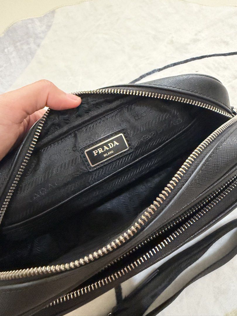 Prada Black Saffiano Leather Camera Bag with Pouch (Category: Luxury Bags & Wallets) located in Cebu City. Submitted by gdcebu (Listing ID 1454198185, Image 3). Description: - Prada Camera Bag - Color: Black - Material: Saffiano Leather - Features: Adjustable Prada shoulder strap, small matching pouch - Interior: Lined with Prada branded fabric - Condition: Smooth zippers, great for everyday use or travel.