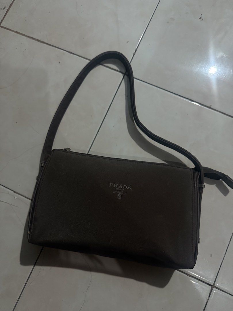 Prada Milano Brown Shoulder Bag NEEDS CLEAN ONLY (Category: Luxury Bags & Wallets) located in Tanauan. Submitted by swifttiger.c7f149 (Listing ID 1454355465, Image 1). Description: - Brown Prada shoulder bag - Main compartment with interior zip pocket - Exterior in decent condition - Adjustable strap for comfortable wear - Perfect for everyday use.