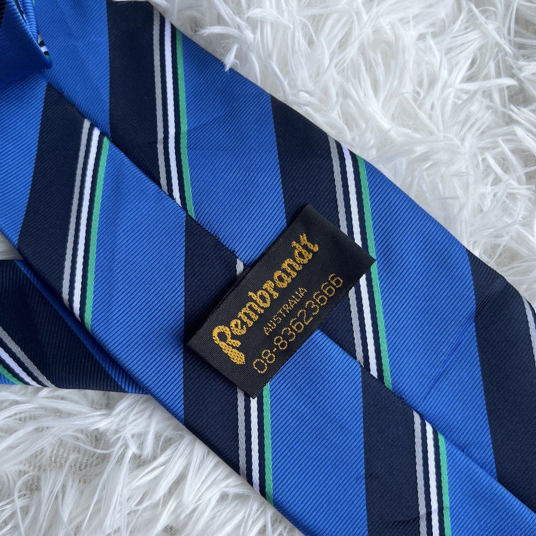 Rembrandt Australia Blue Striped Tie (Category: Ties) located in Cuyapo. Submitted by Ashtyn.Pre.Loved (Listing ID 1454224446, Image 2). Description: - Blue striped tie from Rembrandt Australia. - Features a diagonal stripe pattern. - Color accents: navy, royal blue, white, and green. - Rembrandt logo on the front. - Ideal for formal or business wear. - Please check photos for detailed condition..
