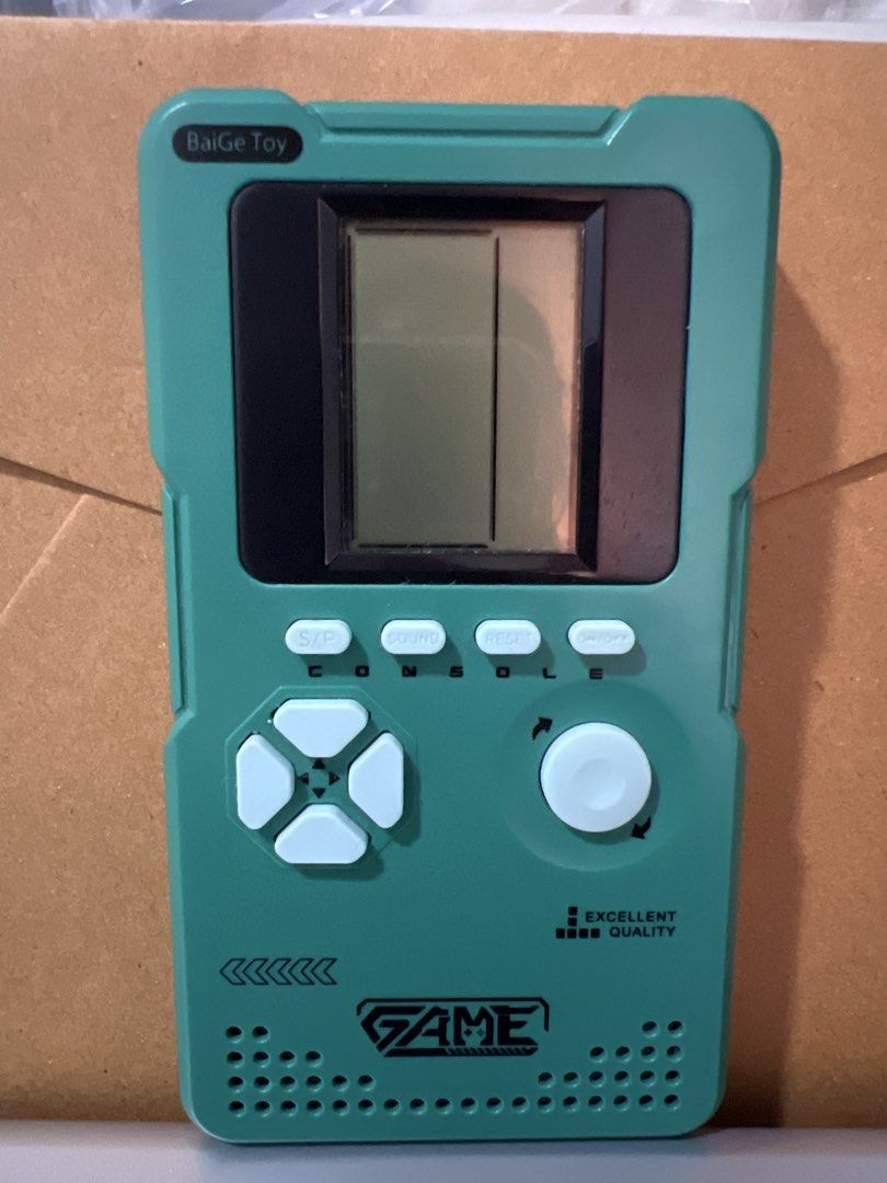 Retro Handheld Game Console - Tetris Brick Game (Category: Nintendo) located in Manila. Submitted by _nicaamae (Listing ID 1454236853, Image 2). Description: - Classic handheld game console - Plays Tetris and other brick games - Features directional pad and action buttons - Perfect for quick gaming sessions - Fun for all ages - Comes in a cool teal/green color.