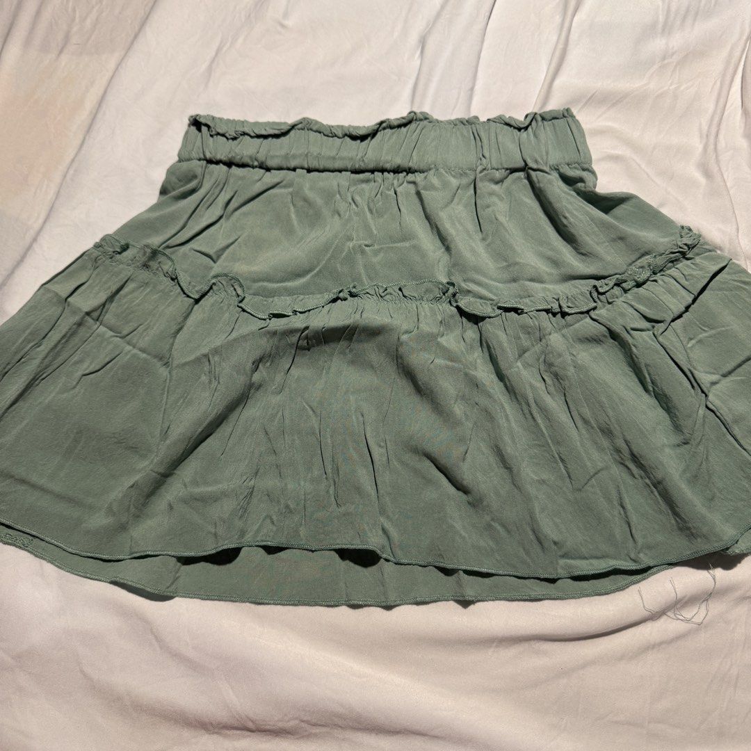 Sage Green Tiered Ruffle Mini Skirt (Category: Skirts) located in Rizal. Submitted by zlaaa_ (Listing ID 1454209083, Image 1). Description: - Sage green mini skirt - Comfortable elasticated waistband - Two tiers with charming ruffle details - Lightweight fabric, perfect for warm weather - Effortlessly style with tees or dressy tops 📍Loc: Rod. Rizal 🚚 MOD: J&T, Lalamove (buyer shoulders shipping) 💳 MOP: Gcash, Maribank, or Bank Transfer ❗️Payme
