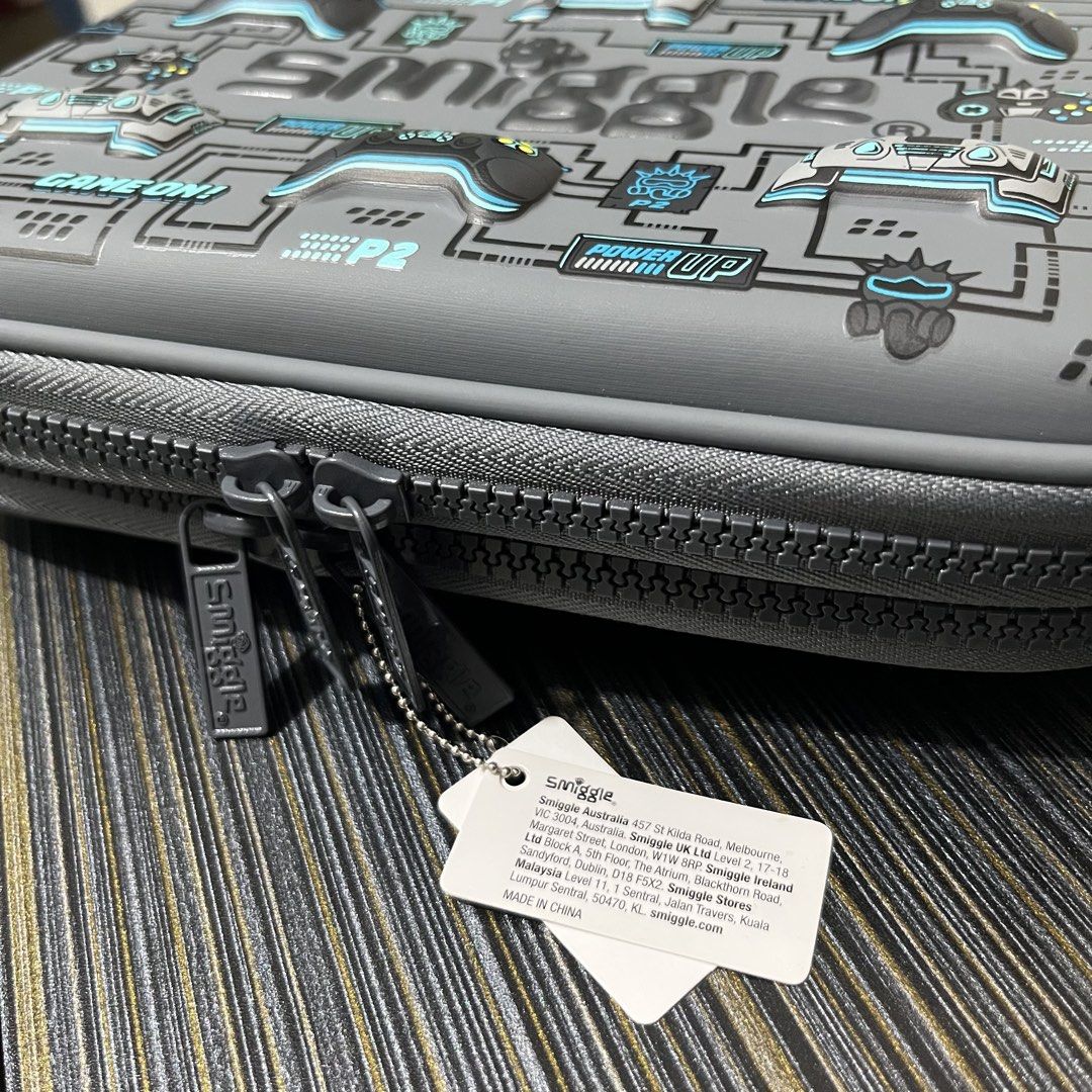 Smiggle Gaming Controller Pencil Case (Category: Stationery & School Supplies) located in Quezon City. Submitted by sgsofficialstore (Listing ID 1454228747, Image 2). Description: - Cool Smiggle pencil case with a fun gaming controller design. - Spacious interior to hold all your stationery needs. - Features multiple compartments for organized storage. - Includes a convenient mesh pocket. - Secure zip closure to keep everything safe. - Ideal for 