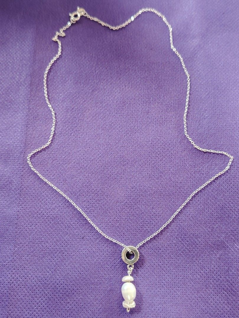 Sterling Silver Necklace with Pearl Pendant (Category: Necklaces) located in Baguio. Submitted by ezelmix94436 (Listing ID 1454364482, Image 3). Description: - Genuine sterling silver chain necklace - Stamped '925' and 'ITALY' on the clasp - Features a circular pendant with a dark stone - Adorned with a unique, irregular shaped dangling pearl - Simple, classic, and elegant design.
