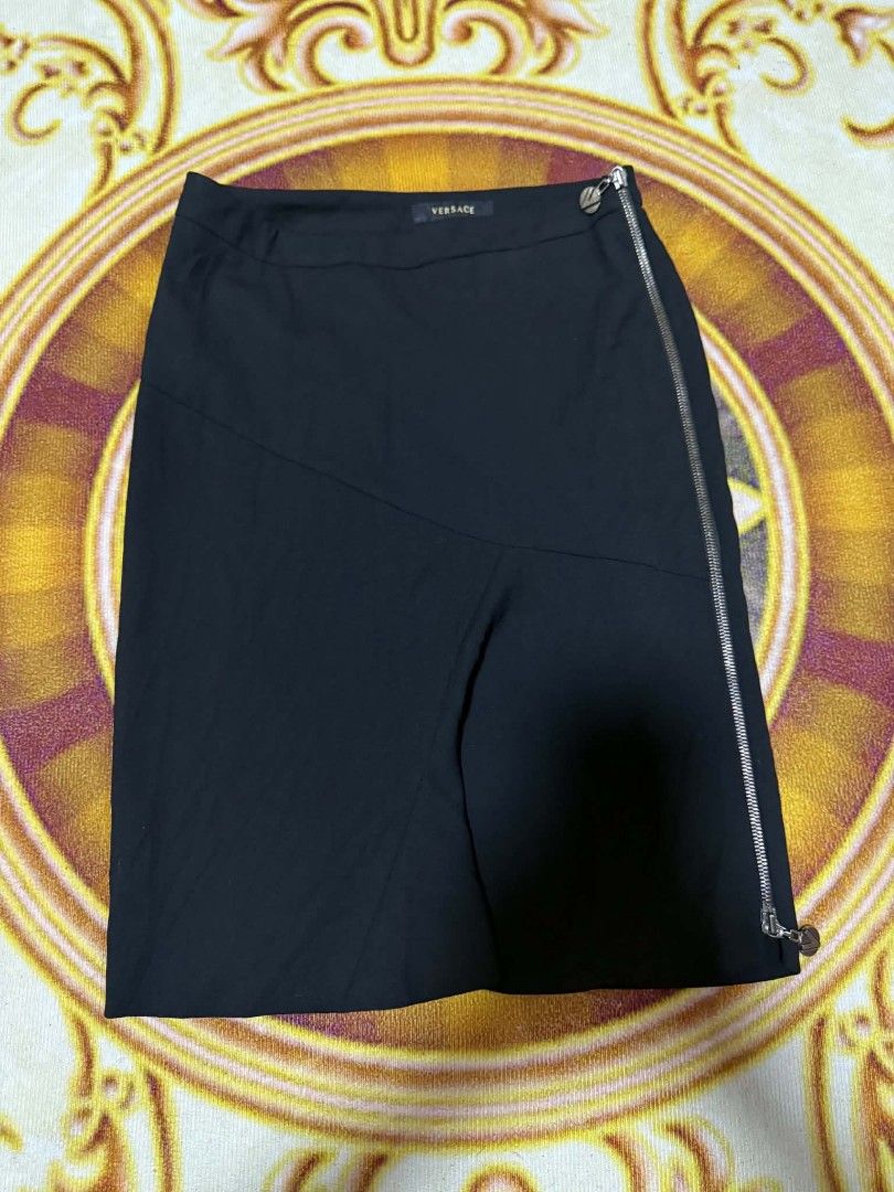 Gianni Versace Asymmetrical Zip Midi Skirt (Category: Skirts) located in General Santos City (Dadiangas). Submitted by stayrid (Listing ID 1454304452, Image 1). Description: - Size 38 / 4 - Length 21 - Color Black - Working All Zipper - Authentic Versace midi skirt - Unique asymmetrical design. - Features a prominent silver zipper detail on the side. - Zipper includes a small, stylish charm. - Versatile for dressing up or down..