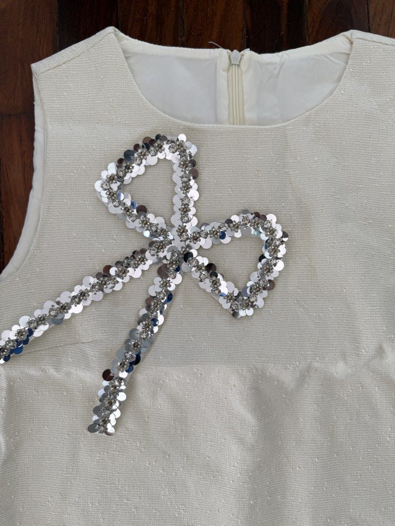 White sequin bow crop top and skirt set (Category: Sets or Coordinates) located in Pasig City. Submitted by atbp__ (Listing ID 1454303229, Image 2). Description: - Adorable white two-piece set - Sleeveless crop top with sparkly sequin bow detail - Matching high-waisted skirt - Zipper closure on the top - Ideal for parties and events - Sold as a set.