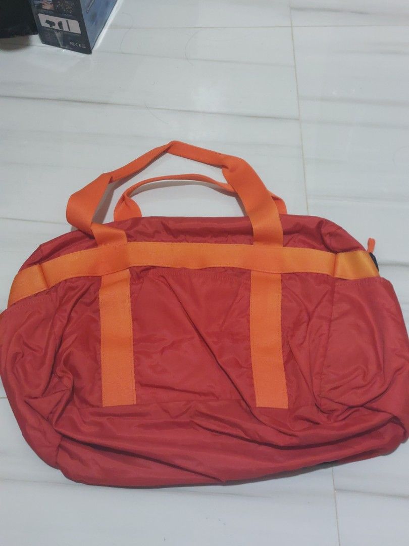 ASICS Red Duffel Bag with Orange Straps (Category: Sling Bags) located in Malaybalay. Submitted by mags_sofia (Listing ID 1454496253, Image 2). Description: - Red ASICS duffel bag - Orange straps and handles - Main zippered compartment - Interior ASICS branding - Ideal for gym or travel - Made with durable material.