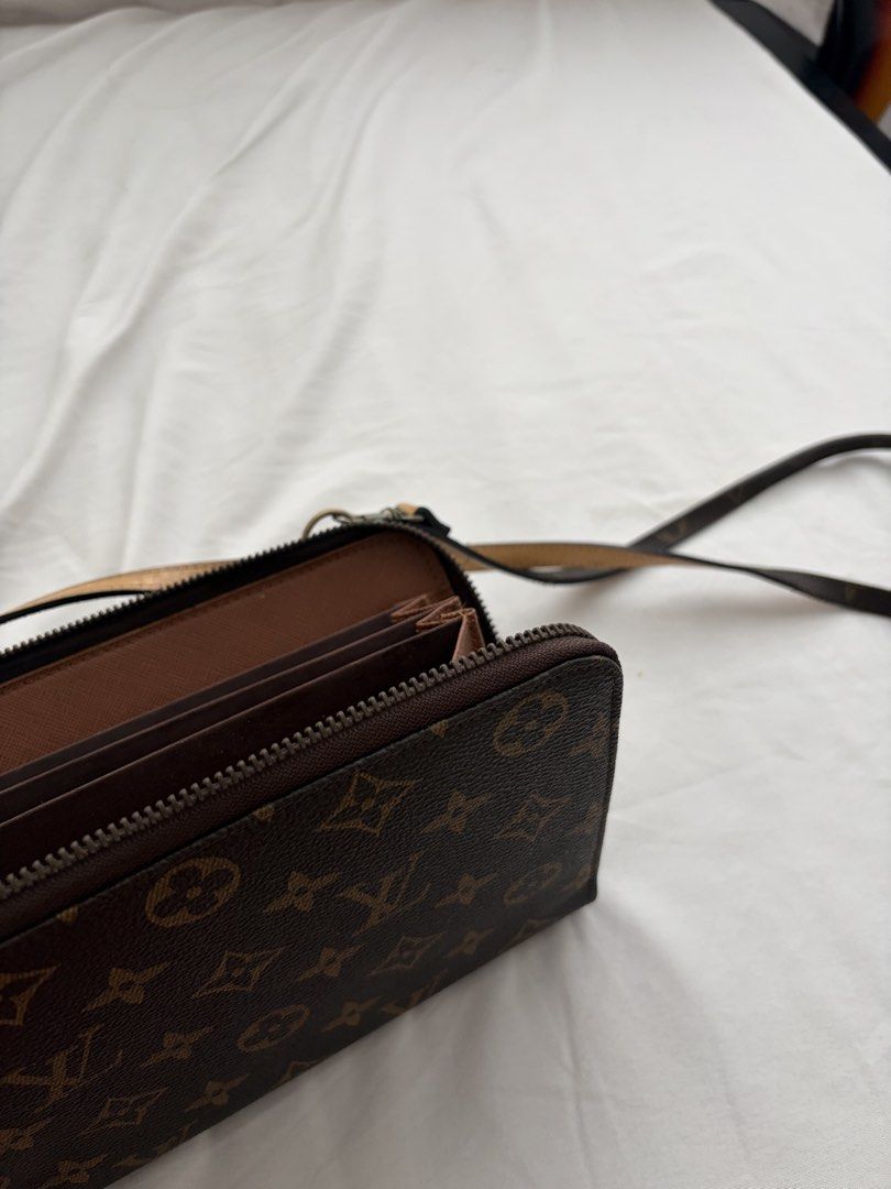 Louis Vuitton Monogram Canvas Wallet Clutch with Strap (Category: Luxury Bags & Wallets) located in Quezon City. Submitted by clareb (Listing ID 1454379119, Image 3). Description: - Louis Vuitton Monogram Canvas Wallet - Secure zip-around closure - Multiple interior card slots and buttons compartments for organization - Detachable strap allows for versatile use as a crossbody bag or clutch.