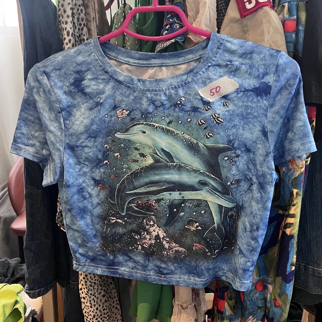 Blue Dolphin Tie-Dye Crop Top (Category: Shirts) located in Quezon City. Submitted by aasspp (Listing ID 1454454822, Image 1). Description: - Cool blue tie-dye crop top - Features a fun dolphin and fish graphic - Short sleeves and crew neck design - Perfect for casual, ocean-themed outfits - Estimated size: Small to Medium - Original price tag: PHP 50.