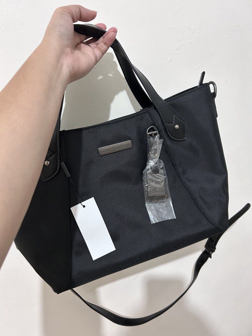 Calvin Klein Jeans Black Tote Bag (Category: Tote Bags) located in Pasig City. Submitted by krishnasingh2020 (Listing ID 1454553235, Image 1). Description: - Brand new Calvin Klein Jeans tote bag - Original tags still attached - Features top handles - Includes a detachable shoulder strap - Made from durable material - Spacious interior for all your essentials.