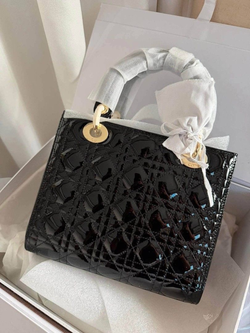 Christian Dior Lady Dior (Category: Luxury Bags & Wallets) located in Santa Cruz. Submitted by Authentic_Branded_Bags (Listing ID 1454514508, Image 1). Description: Christian Dior Lady Dior satchel in black patent leather with the iconic cannage stitching and gold-finish charms. The bag features a quilted texture created by the signature cannage motif. It is adorned with pale gold-finish "D.I.O.R." charms. This style can be carried by hand or wor