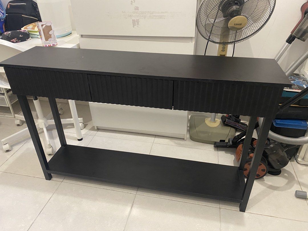 Console Table (Category: Tables & Sets) located in Subang Jaya. Submitted by masturahmalek (Listing ID 1454485366, Image 1). Description: - Stylish black console table - Features 3 drawers with unique ribbed front design - Additional lower shelf for extra storage - Modern angled legs for a contemporary look - Dimensions: 130cm (length), 80 (height) - Ideal for entryways, hallways, or living room spaces.