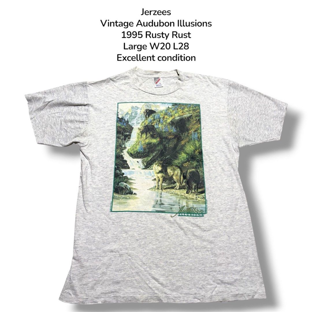 Jerzees Vintage Audubon Illusions 1995 Rusty Rust T-Shirt (Category: Tshirts & Polo Shirts ) located in Guihulngan. Submitted by fbthriftgoodsniace (Listing ID 1454388913, Image 1). Description: - Vintage 1995 Jerzees T-Shirt - Features 'Audubon Illusions' graphic: wolf and waterfall scene - Graphic also includes 'Rusty Rust' and 'Prince Island Apparel' - Approximate Measurements: 20 inches wide x 28 inches long - Excellent vintage condition, a u