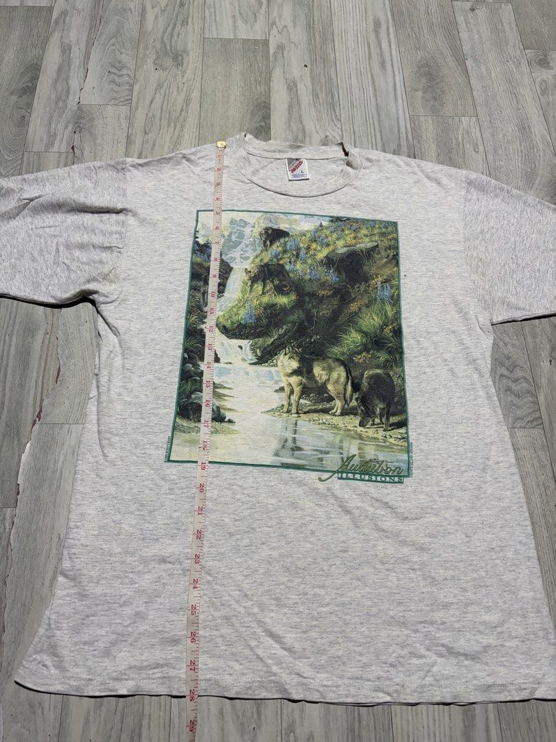 Jerzees Vintage Audubon Illusions 1995 Rusty Rust T-Shirt (Category: Tshirts & Polo Shirts ) located in Guihulngan. Submitted by fbthriftgoodsniace (Listing ID 1454388913, Image 3). Description: - Vintage 1995 Jerzees T-Shirt - Features 'Audubon Illusions' graphic: wolf and waterfall scene - Graphic also includes 'Rusty Rust' and 'Prince Island Apparel' - Approximate Measurements: 20 inches wide x 28 inches long - Excellent vintage condition, a u